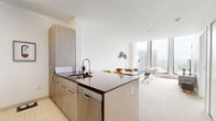 Located in the heart of Hartford, CT, this thoughtfully designed two-bedroom, one-bathroom residence offers a modern urban living experience with clean lines and a bright, contemporary aesthetic throughout. The open-concept living room is bathed in natural light through dramatic floor-to-ceiling windows that frame sweeping views of the Hartford skyline, creating an inviting and airy atmosphere. Neutral-toned carpeting and crisp white walls provide a versatile backdrop throughout the home.

The primary bedroom is a serene retreat, featuring expansive corner windows that maximize city views on two sides, filling the room with natural light. The second bedroom offers a comfortable and functional layout, also finished with soft carpeting and clean white walls. A dedicated closet with built-in shelving rods provides generous storage space.

The bathroom is finished with large-format dark slate tile flooring, a sleek wall-mounted vanity with rich wood cabinetry, and a full tub-shower combination, delivering a clean and modern aesthetic. A hallway connects the rooms efficiently, maintaining the home's streamlined flow. The overall ambiance is bright, minimalist, and urban — ideal for those seeking a polished residence in downtown Hartford.