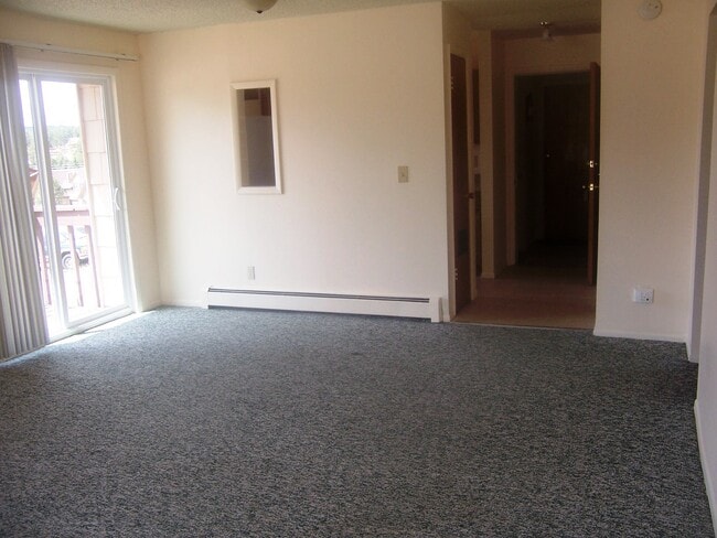 La sala de estar/comedor tiene una práctica abertura que la conecta con la cocina. También cuenta con una puerta que da al patio. - 506 Mountain View Pl