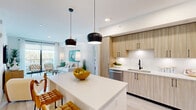 Located at 15705 SW 127th Ave in Miami, FL, this single-level 3-bedroom, 2-bathroom residence offers a bright, contemporary living experience with cohesive design throughout. The open-concept living room features light wood-style flooring, recessed lighting, and a large sliding glass door that invites natural light and provides outdoor views, creating an airy, welcoming atmosphere. The kitchen is outfitted with light wood cabinetry, stainless steel appliances, a white quartz center island with bar seating, and sleek pendant lighting — ideal for both everyday use and entertaining. The primary bedroom offers a comfortable, well-lit retreat with a ceiling fan, large windows, and soft coastal-inspired decor. Additional bedrooms feature soft sage-green walls, ceiling fans, and generous natural light from large windows. Two dedicated closets provide practical storage throughout. The bathrooms are finished with elegant marble-style tile, including a primary bath with a glass-enclosed walk-in shower and soaking tub combination, and a secondary bath featuring a tub-shower combo with marble surround and a wood-toned vanity with quartz countertop. Light wood flooring and a clean, neutral palette tie the entire residence together into a cohesive and inviting home.