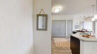 Located in College Station, Texas, this single-story 2-bedroom, 2-bathroom residence offers a thoughtfully designed open-concept layout with modern finishes throughout. Light wood-look flooring flows through the main living areas, complemented by crisp white walls and abundant natural light from large windows. The kitchen serves as a central hub, featuring rich dark cabinetry, granite countertops, stainless steel appliances, and a curved island with bar seating and pendant lighting—ideal for both cooking and casual dining. The adjacent dining area benefits from direct outdoor access and built-in shelving, adding both function and character. The living room offers generous window coverage and views of the surrounding neighborhood. Both bedrooms are carpeted and well-sized, with the primary bedroom featuring a walk-in closet outfitted with wire shelving and hanging rods. The primary bathroom includes a dual-sink vanity with dark wood cabinetry, granite countertops, and hardwood-style flooring. The second bedroom is bright and airy, with large windows that invite natural light. A dedicated hallway and entrance area complete the floor plan, providing a practical and welcoming flow throughout this well-designed residence.