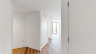Located at 2800 SW 27th Terrace in Miami's vibrant Coconut Grove neighborhood, this modern 2-bedroom, 1-bathroom residence offers a thoughtfully designed layout with clean lines and a contemporary aesthetic throughout. The open-concept kitchen is a standout feature, showcasing floor-to-ceiling light wood cabinetry, white subway tile backsplash, a full suite of stainless steel appliances including a range, dishwasher, microwave, and refrigerator, and a generous white quartz island that flows seamlessly into the living area. Warm wood-style flooring runs throughout the entire residence, adding a welcoming contrast to the crisp white walls and recessed lighting overhead. The living area opens to a private balcony through floor-to-ceiling sliding glass doors, offering elevated views of the surrounding Miami cityscape. Both bedrooms are bright and airy, with large windows framing sweeping outdoor views and vertical blinds for privacy. The primary bedroom provides a comfortable footprint with generous natural light. The full bathroom is finished in a clean, minimalist style with a white tile tub-shower combo, stone-topped vanity with wood cabinetry, and large-format tile flooring. A dedicated closet completes the efficient and well-appointed floor plan.