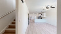 This two-story home on Bost Drive in Fort Smith, Arkansas offers a thoughtfully designed layout spread across two floors. The main floor hosts an open-concept living room and kitchen combination, where light luxury vinyl plank flooring, neutral cream walls, and ceiling fans create a bright, cohesive atmosphere. The kitchen is well-appointed with white shaker cabinetry, granite countertops, stainless steel appliances including a French door refrigerator, electric range, and microwave, along with a peninsula island with a sink and pendant lighting overhead. A glass-panel back door allows additional natural light into the kitchen area.

The upper floor contains both bedrooms, two full bathrooms, and a dedicated laundry room. Each bedroom features light LVP flooring, ceiling fans, and windows that bring in natural light. The primary bedroom is a comfortable, well-proportioned space. The bathrooms are finished with white cabinetry, granite countertops, dual undermount sinks, round mirrors, and matte black hardware and fixtures. Three closets are distributed throughout the home, and a staircase connects the two levels, completing this efficiently planned residential space.