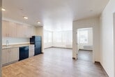 Located at 1621 E 120th Ave in Northglenn, Colorado, this two-bedroom, one-bathroom unit offers a thoughtfully designed single-floor layout with modern finishes throughout. Wood-look plank flooring runs continuously through the living areas, kitchen, and bedrooms, creating a cohesive and clean aesthetic.

The kitchen is well-appointed with light wood cabinetry extending to the ceiling, granite-style countertops, a stainless sink, and a full suite of black appliances including a refrigerator, dishwasher, range, and built-in microwave. Recessed lighting adds a polished touch to the space.

The open living area benefits from large windows that invite generous natural light, while a wall-mounted HVAC unit ensures year-round comfort. A hallway connects the living spaces to the bedrooms, each featuring wood-look flooring, large windows with blinds, and ample wall space. The primary bedroom offers a comfortable footprint, while the secondary bedroom includes a ceiling fan and closet.

The bathroom features a granite-top vanity with wood-toned cabinetry and a large mirror. A dedicated laundry room houses a full-size front-loading washer and dryer set with overhead wire shelving for additional storage. This well-designed unit combines functional living spaces with contemporary finishes in a practical, efficient layout.