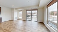 Located in Eagan, MN, this well-appointed one-bedroom, one-bathroom residence offers a thoughtfully designed layout across a generous single floor. The open-concept kitchen and living area serves as the heart of the home, bathed in natural light from large windows and a sliding glass door that leads to a private balcony with outdoor views. Light-toned hardwood flooring flows throughout the main living spaces, creating a clean, modern aesthetic.

The kitchen is a standout feature, showcasing rich dark-stained cabinetry extending to the ceiling, white quartz countertops, a subway tile backsplash, and a full suite of stainless steel appliances including a refrigerator, range, microwave, and dishwasher. A kitchen island adds additional prep and storage space.

The bedroom is a comfortable retreat with plush carpet, a large window overlooking the balcony area, and access to multiple closets, including a generously sized double-door closet. The hallway provides additional closet storage throughout.

The bathroom is finished with dark wood cabinetry, a single vanity with light countertops, a wall-mounted mirror, and hardwood-style flooring, maintaining the consistent design language found throughout the unit. The overall ambiance is modern, light, and move-in ready.