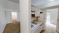 Located in Indianapolis, IN, this single-floor home offers four bedrooms and one full bathroom within a compact, efficiently arranged layout. The kitchen features white cabinetry with wood trim accents, a gas range, and a full-size refrigerator, with an open sightline into the adjacent living area. The living room is carpeted and bright, highlighted by a sliding glass door that opens to an outdoor area and allows generous natural light to fill the space. The four bedrooms are all carpeted and finished with neutral white walls, providing a clean and versatile canvas. Several bedrooms feature windows with views of surrounding greenery, enhancing the sense of openness. Closet configurations vary across the bedrooms — one includes a double sliding-door closet with a built-in shelf and hanging rod, while others feature standard door closets or open configurations. The primary bedroom is notably spacious, offering ample room for furnishings. The single full bathroom includes a tub/shower combo with a white surround, chrome fixtures, and tile flooring. A hallway connects the main living areas to the bedrooms, supporting a straightforward and functional flow throughout the home.