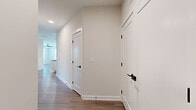 Located at 1500 Bell Road in Nashville, TN, this single-story, 3-bedroom, 2-bathroom home offers a well-designed layout with modern finishes throughout. The open-concept kitchen is a standout feature, showcasing white shaker cabinetry, a white subway tile backsplash, stainless steel appliances, dark granite countertops, and a distinctive curved island with pendant lighting — all set atop light-toned hardwood-style flooring that extends through the main living areas. The living room is bright and airy, featuring a ceiling fan and multiple windows with outdoor views that fill the space with natural light. A central hallway connects the bedrooms, finished with clean white walls, crisp white panel doors, and matte black hardware for a cohesive contemporary look. The bedrooms are carpeted and include ceiling fans, with the secondary bedrooms offering natural light via exterior windows. The primary bedroom is generously sized and connects to a well-appointed en-suite bathroom featuring a double-sink vanity with dark granite countertops, white cabinetry, large-format tile flooring, and a glass-enclosed walk-in shower. The second bathroom also offers a double vanity with matching dark countertops and tile flooring. Two closets provide ample storage throughout the home.