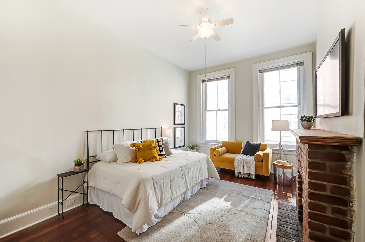 Living area- beautifully refinished pine floor, functioning double-hung windows and brick fireplace. - 309 E 13th St