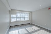 This contemporary 2-bedroom apartment in Toronto offers 640 square feet of efficiently designed living space. The open-concept layout maximizes the use of space, creating a seamless flow between the living areas. The kitchen is a standout feature, boasting white cabinetry, stainless steel appliances, and a functional island with a sink, perfect for meal preparation and casual dining.

Both bedrooms are well-proportioned, with the primary bedroom measuring 110 square feet. Large windows in each room flood the space with natural light, while baseboard heaters ensure comfort year-round. The bathroom is a luxurious retreat, featuring marble-look tiles, a modern vanity, and a combined tub and shower with a curved rod.

Throughout the apartment, neutral-toned walls and light wood-look flooring create a bright, airy ambiance. Recessed lighting and mirrored closet doors in the bedrooms add to the sense of spaciousness. The unit also includes practical amenities such as in-unit laundry and ample storage space.

Located at 87 Jameson Ave in Toronto, this apartment offers urban living with modern comforts. Its efficient design and updated features make it an attractive option for those seeking a contemporary living space in the heart of the city.