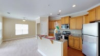 This single-story residence is designed with a cohesive, neutral color palette of warm beige tones throughout, creating a bright and welcoming ambiance. Crown molding accents the main living areas, adding a refined architectural detail.

The kitchen serves as a central hub of the home, featuring warm honey-toned cabinetry with raised-panel doors, granite countertops, and a full suite of stainless steel appliances, including a range, built-in microwave, and refrigerator. A peninsula with bracket-supported overhang provides convenient bar seating and opens directly to the living area, which is finished with plush carpeting and recessed lighting.

The generously sized primary bedroom benefits from multiple windows offering outdoor views and greenery, along with a ceiling fan for added comfort. Additional bedrooms are similarly appointed with carpet flooring, ceiling fans, and natural light. The primary bathroom features an extended granite-topped vanity with dual sinks, rich hardwood-style flooring, and a separate water closet, while a secondary bathroom offers a shower-tub combination with a matching granite vanity.