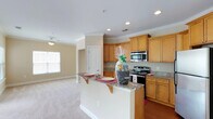 This single-story residence is designed with a cohesive, neutral color palette of warm beige tones throughout, creating a bright and welcoming ambiance. Crown molding accents the main living areas, adding a refined architectural detail.

The kitchen serves as a central hub of the home, featuring warm honey-toned cabinetry with raised-panel doors, granite countertops, and a full suite of stainless steel appliances, including a range, built-in microwave, and refrigerator. A peninsula with bracket-supported overhang provides convenient bar seating and opens directly to the living area, which is finished with plush carpeting and recessed lighting.

The generously sized primary bedroom benefits from multiple windows offering outdoor views and greenery, along with a ceiling fan for added comfort. Additional bedrooms are similarly appointed with carpet flooring, ceiling fans, and natural light. The primary bathroom features an extended granite-topped vanity with dual sinks, rich hardwood-style flooring, and a separate water closet, while a secondary bathroom offers a shower-tub combination with a matching granite vanity.