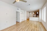 Located in Katy, TX, this well-designed one-bedroom, one-bathroom residence offers a thoughtfully organized single-floor layout. Light wood-style flooring runs throughout, creating a warm and cohesive aesthetic across every room. The open-concept living and dining area is bright and airy, benefiting from multiple large windows that frame outdoor greenery and fill the space with natural light. A ceiling fan overhead adds to the comfortable ambiance. The kitchen is equipped with warm-toned cabinetry, stainless steel appliances including a refrigerator with an ice and water dispenser, a white quartz island with pendant lighting, and tile backsplash details. A built-in mudroom nook near the entrance provides wall hooks and lower shelving for organized storage. The bedroom is a well-proportioned retreat with windows overlooking a landscaped outdoor area, offering ample natural light and a ceiling fan. The bathroom features a double-sink vanity with white quartz countertops, brushed nickel hardware, a lighted mirror, and a marble-tiled walk-in shower. A dedicated laundry area and multiple closets throughout the hallway provide generous storage. The unit offers a clean, modern finish with a practical and functional floor plan.