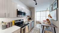 Located at 530 Meeting St in the heart of Charleston, SC, this thoughtfully designed one-bedroom, one-bathroom residence offers an efficient and modern living experience across a single floor. The open-concept layout maximizes every square foot, creating a seamless flow between the kitchen, living area, and bedroom.

The kitchen is a standout feature, equipped with full stainless steel appliances including a range, over-the-range microwave, refrigerator, and dishwasher. Light wood-grain cabinetry stretches from floor to ceiling, complemented by clean white quartz countertops and a classic subway tile backsplash. Light hardwood-style flooring runs throughout, tying the space together cohesively.

The bedroom is bathed in natural light from large windows dressed with sheer white curtains and plantation shutters, and is finished with a ceiling fan for added comfort. A dedicated workspace area makes the room functional for both rest and productivity.

The bathroom features a full tub-shower combination with white subway tile surround, a granite-topped vanity with wood-grain cabinetry, and a framed mirror. The neutral color palette throughout the space lends a clean, contemporary aesthetic. This residence offers a smart and stylish option for urban living in one of Charleston's most walkable and historic neighborhoods.