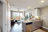 Located at 1360 West University Avenue in Gainesville, FL, this 2-bedroom, 2-bathroom residence offers a well-designed open-concept layout across a single floor. The kitchen serves as a central hub, featuring granite-style countertops, contemporary flat-front cabinetry, stainless steel appliances including a dishwasher and refrigerator, and a peninsula that flows seamlessly into the living area. The living room is bright and inviting, with wood-style plank flooring, a ceiling fan, and large sliding glass doors that open onto a private balcony with open views of the surrounding Gainesville skyline and treetops. Each bedroom offers carpeted flooring, neutral tones, and dedicated closet space with built-in wire shelving. The primary bedroom includes its own bathroom, while the second bathroom features a tub-shower combination, a vanity with granite-style counters, and tile flooring. An in-unit laundry area with a stacked washer and dryer adds convenience, while a utility room and two closets provide ample storage. The space maintains a cohesive, modern aesthetic with neutral gray walls and contemporary finishes throughout.