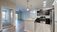 Located at 13401 Legendary Dr in Austin, TX, this well-appointed 2-bedroom, 2-bathroom residence offers a thoughtfully designed single-floor layout. The open-concept living, dining, and kitchen area forms the heart of the home, anchored by light wood-style flooring and a ceiling fan that enhances airflow and comfort. Sliding glass doors lead to a private balcony framed by lush, mature trees — an ideal outdoor retreat.

The kitchen is a standout feature, equipped with rich dark espresso cabinetry, granite-style countertops, a classic subway tile backsplash, and a full suite of stainless steel appliances including a range, microwave, dishwasher, and refrigerator. A center island with a sink and pendant lighting adds both function and style.

Both bedrooms are carpeted for comfort and include ceiling fans and ample closet space. The primary bedroom offers a generous footprint with direct access to its own bathroom. Both bathrooms feature tile flooring, dark vanity cabinetry with granite countertops, and tiled shower/tub combinations. Additional conveniences include a dedicated laundry area, pantry, utility room, and hallway storage, making this a highly functional and comfortable Austin residence.