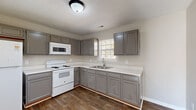 Located at 609 Landers St in Shelbyville, Tennessee, this single-story, 2-bedroom, 1-bathroom home offers a practical and comfortable layout. The kitchen is a standout feature, outfitted with gray shaker-style cabinetry, light quartz-style countertops, a stainless steel sink, and white appliances including a range, over-the-range microwave, and refrigerator. Wood-look plank flooring runs throughout the kitchen and utility areas, lending a warm, cohesive aesthetic. The living room is bright and welcoming, featuring plush carpet, a ceiling fan, and an open sightline into the kitchen, making the space feel connected and airy. Natural light streams through windows, casting light across the carpeted floors. Both bedrooms are well-proportioned, each equipped with a ceiling fan and windows that bring in ample natural light and outdoor views of the surrounding neighborhood. Three closets throughout the home provide generous storage. The bathroom is clean and functional, featuring a full tub-shower combo, a gray vanity with a light countertop, a toilet, and wood-look tile flooring. A dedicated utility room and hallway round out the thoughtfully arranged floor plan, making efficient use of the available space.