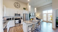 Located at 3100 Technology Blvd W in Bozeman, Montana, this thoughtfully designed one-bedroom, one-bathroom residence makes excellent use of its single-floor layout. Soaring ceilings throughout the open-concept kitchen and living area create a striking sense of volume and airiness rarely found in a space of this scale.

The kitchen is a standout feature, outfitted with crisp white shaker cabinetry, granite countertops, a classic subway tile backsplash, and a full suite of stainless steel appliances. A granite-topped island with bar seating serves as both a functional workspace and a natural gathering point that transitions seamlessly into the living area.

The living room benefits from large floor-to-ceiling windows and a glass patio door that invites abundant natural light and provides outdoor views of the surrounding Bozeman landscape. Warm hardwood-style flooring flows consistently throughout the main living areas, complementing the light, neutral color palette.

The bedroom is a comfortable and well-lit retreat, featuring large windows and a ceiling fan. A dedicated closet provides practical storage. The bathroom is clean and straightforward, featuring a tub-shower combination with tile surround and granite-accented vanity, consistent with the refined finishes found throughout the home.