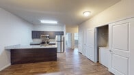 Located at 170 Cycle Dr in Boiling Springs, SC, this single-story unit offers a thoughtfully designed open-concept layout that connects the kitchen, dining, and living areas seamlessly. Wood-style flooring runs throughout the main living spaces, contributing to a clean, cohesive aesthetic.

The kitchen is well-appointed with dark espresso cabinetry, granite countertops, and a full suite of stainless steel appliances including a refrigerator, electric range, and over-the-range microwave. A kitchen island provides additional counter space and defines the transition into the living area. Pendant lighting accents the space overhead.

The generously sized living area features wood-style flooring, a ceiling fan, and natural light from a window. A separate dining or flex area connects fluidly to the kitchen via an open corridor.

The bedrooms are carpeted for comfort and include ceiling fans and windows that allow natural light. Each bedroom features closet storage, and the primary bedroom is accompanied by an en-suite bathroom with granite-topped vanity and dark cabinetry. A second bathroom mirrors this design, featuring a tub/shower combination, granite vanity, and wood-style flooring. A dedicated laundry area with washer and dryer hookups is also present within the unit.