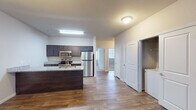 Located at 170 Cycle Dr in Boiling Springs, SC, this single-story unit offers a thoughtfully designed open-concept layout that connects the kitchen, dining, and living areas seamlessly. Wood-style flooring runs throughout the main living spaces, contributing to a clean, cohesive aesthetic.

The kitchen is well-appointed with dark espresso cabinetry, granite countertops, and a full suite of stainless steel appliances including a refrigerator, electric range, and over-the-range microwave. A kitchen island provides additional counter space and defines the transition into the living area. Pendant lighting accents the space overhead.

The generously sized living area features wood-style flooring, a ceiling fan, and natural light from a window. A separate dining or flex area connects fluidly to the kitchen via an open corridor.

The bedrooms are carpeted for comfort and include ceiling fans and windows that allow natural light. Each bedroom features closet storage, and the primary bedroom is accompanied by an en-suite bathroom with granite-topped vanity and dark cabinetry. A second bathroom mirrors this design, featuring a tub/shower combination, granite vanity, and wood-style flooring. A dedicated laundry area with washer and dryer hookups is also present within the unit.