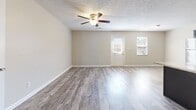 Located at 1060 Shive Ln in Bowling Green, Kentucky, this two-story home offers a practical and comfortable layout with consistent finishes throughout. The main living area features durable wood-style flooring and a ceiling fan, with natural light streaming in through multiple windows and a glass-paneled entry door that connects the interior to the outdoors.

The kitchen is a standout feature, equipped with dark navy cabinetry, light granite-style countertops, stainless steel appliances including a range, dishwasher, and refrigerator, as well as a double sink — all set atop matching wood-style flooring that ties the space together seamlessly.

The bedrooms are carpeted for comfort, each featuring ceiling fans and windows that bring in natural light. At least one bedroom includes a walk-in closet with built-in shelving, adding valuable storage. Textured ceilings are present throughout the home, giving each room a classic residential feel.

The bathroom is well-appointed with dark cabinetry, a white countertop vanity, wood-style tile flooring, and a tub-shower combination. An additional utility or storage room with a concrete floor and electrical panel provides extra functional space. The home's neutral color palette and consistent finishes create a cohesive, move-in-ready environment.