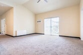 Located at 815 Commons Cir in Plover, WI, this two-story home offers a well-organized layout across two levels. The lower level houses an attached garage with an automatic opener, drywalled walls, and a concrete floor, providing direct interior access to the main living space. The primary floor is where most of the living takes place, beginning with a welcoming entrance that leads into a bright, open-concept living and dining area. This generous space features vaulted ceilings, soft carpeting, and a sliding glass door that opens to a private patio with outdoor views. The kitchen is outfitted with rich dark wood cabinetry, granite-style countertops, stainless steel appliances including a range, microwave, and refrigerator, and durable hardwood-style flooring. A dedicated laundry room accommodates a full-size front-loading washer and dryer with overhead wire shelving. The three bedrooms are carpeted and include closets with bifold doors, offering ample storage. Two bathrooms feature wood-toned vanities with stone-look countertops, a tub/shower combination, and hardwood-style flooring. A carpeted staircase with a handrail connects the levels, completing this functional and comfortable home.