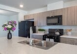 This 1280 square foot residence in Fort Liberty, North Carolina, offers a well-designed living space across two floors. The home features three bedrooms, including a generous 200 square foot primary bedroom, and one bathroom. The ground floor spans 650 square feet, while the upper level covers 630 square feet.

The interior showcases a mix of flooring materials, including warm hardwood in some bedrooms and durable laminate in other areas, adding character to each space. The bathroom is equipped with modern fixtures, including a bathtub-shower combination and a sleek vanity. 

The kitchen is a highlight, boasting crisp white cabinetry, granite countertops, and stainless steel appliances. A window above the sink allows natural light to illuminate the space. The living areas are bright and airy, with large windows providing ample natural light and views of the surroundings.

Ceiling fans in the bedrooms offer additional comfort and air circulation. The home's layout includes a living room, two hallways, and a staircase connecting the two floors, ensuring easy navigation throughout the space. With its blend of modern amenities and thoughtful design, this home provides a comfortable and functional living environment for its occupants.