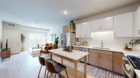 Located in Cottage Grove, MN, this 2-bedroom, 2-bathroom residence offers a thoughtfully designed open-concept layout with modern finishes throughout. The combined kitchen and living area serves as the heart of the home, featuring white shaker-style cabinetry, a classic subway tile backsplash, stainless steel appliances, and a central island with bar seating — ideal for both cooking and casual dining. Light wood-style flooring flows throughout the main living areas, enhancing the bright, airy atmosphere created by large windows. The living room offers generous space and opens directly to a private balcony, where sweeping views of lush greenery and a winding waterway provide a tranquil outdoor retreat. The primary bedroom is well-proportioned, featuring plush carpet, large windows with natural light, and ample closet storage. The second bedroom is equally inviting with soft carpet and a sizable window overlooking the trees. Both bathrooms are finished with warm wood-tone vanities, light flooring, and clean, neutral palettes. A hallway connects the private spaces efficiently, and three closets provide excellent storage throughout. This residence balances contemporary design with comfortable, functional living.