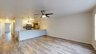Located in Austin's vibrant 78704 corridor, this single-story, 2-bedroom, 1-bathroom home offers a well-designed open-concept layout that maximizes every square foot. Wood-look flooring runs throughout, lending a warm, cohesive feel across all living areas.

The combined kitchen and living room forms the heart of the home. The kitchen features a spacious quartz-topped peninsula with an undermount sink, stainless steel appliances including a refrigerator, range, and microwave, plus a mosaic tile backsplash and pendant lighting overhead. A ceiling fan anchors the living area, which flows seamlessly from the kitchen peninsula.

Both bedrooms are outfitted with wood-look flooring and ceiling fans, providing comfortable, versatile spaces. The primary bedroom benefits from a large window that invites natural light, while a dedicated walk-in closet offers built-in shelving and double hanging rods for generous storage.

The bathroom is a standout feature, showcasing a full soaking tub surrounded by floor-to-ceiling marble-look tile in white and gold tones, paired with brushed nickel fixtures for a refined finish.

Clean white walls, crisp baseboards, and consistent flooring throughout create a bright, move-in-ready atmosphere well suited to Austin living.