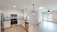 Located at 6080 Tides Way in Myrtle Beach, SC, this single-floor residence offers a clean, modern aesthetic with consistent finishes throughout. The open-concept kitchen serves as the heart of the home, showcasing granite countertops, white shaker cabinetry with matte black hardware, and a classic subway tile backsplash. A central island with an undermount sink and pendant lighting above adds both function and style, while stainless steel appliances — including a refrigerator, range, microwave, and dishwasher — complete the space. The kitchen flows seamlessly into the living area, which features light wood-look flooring and a ceiling fan, creating a bright, airy atmosphere.

The bedrooms are carpeted for comfort, each receiving natural light through windows with blinds and equipped with ceiling fans. The primary bathroom offers a granite-topped double vanity, a large framed mirror, wood-look flooring, and a separate walk-in shower. A second bathroom mirrors the same refined finishes, featuring a single granite vanity and a tub-shower combination. Neutral tones and consistent design elements tie each room together, resulting in a cohesive, move-in-ready residence with a polished, contemporary feel.