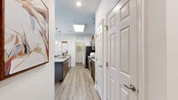This thoughtfully designed single-story residence offers 2 bedrooms and 2 bathrooms across a comfortable, efficiently laid-out floor plan. The open-concept kitchen and living area serves as the heart of the home, featuring warm wood-tone cabinetry, granite countertops, a subway tile backsplash, and stainless steel appliances including a refrigerator, range, and microwave. A skylight above the kitchen fills the space with natural light, while light wood-style flooring runs throughout the main areas. The living room is bright and welcoming, with a ceiling fan, large windows, and direct access to an exterior door, creating an airy, connected feel. Both bedrooms are carpeted and receive natural light through windows; the primary bedroom includes its own dedicated closet and en-suite bath access. The bathrooms are finished with granite-topped dark wood vanities and wood-look flooring. A dedicated in-unit laundry room with full-size washer and dryer hookups adds everyday convenience. Two closets provide ample storage throughout. The overall aesthetic is clean and modern, with neutral tones and consistent finishes that create a cohesive, move-in-ready environment.
