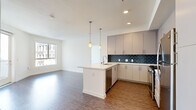 Located in the heart of downtown Los Angeles, this modern 2-bedroom, 2-bathroom residence offers a well-designed single-floor layout with contemporary finishes throughout. The open-concept kitchen and living area serves as the centerpiece of the home, featuring wood-style flooring, recessed lighting, and a large window that floods the space with natural light. The kitchen is outfitted with sleek grey cabinetry, a striking navy blue subway tile backsplash, quartz countertops, a central island with a built-in sink, pendant lighting, and a full suite of stainless steel appliances including a gas range, microwave, dishwasher, and refrigerator. The living area extends toward a private balcony accessible through a glass door, offering views of the surrounding cityscape. Both bedrooms are carpeted and bright, benefiting from large windows with urban views, and each has access to a dedicated closet. The two bathrooms maintain a clean, minimalist aesthetic with white tile tub-shower combos, wood-style flooring, and mirrored medicine cabinets. A hallway connects the private quarters to the main living space, completing this efficiently laid-out urban residence.