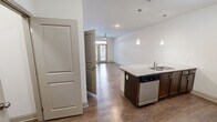 Located at 811 Evolve Way in Knoxville, TN, this one-bedroom, one-bathroom unit offers a thoughtfully designed single-floor layout with efficient use of space throughout. The open-concept living and kitchen area serves as the heart of the home, featuring hardwood-style flooring that extends across the main living spaces. The kitchen is equipped with dark espresso cabinetry, granite countertops, a subway tile backsplash, and a full suite of stainless steel appliances including a refrigerator, range, microwave, and dishwasher. A peninsula with pendant lighting provides additional prep space and casual seating. The living area is bright and airy, benefiting from natural light through French doors that open to the outdoors, complemented by a ceiling fan overhead. The bedroom offers plush carpeting, a ceiling fan, a window with natural light, and access to multiple closets, providing ample storage. The bathroom features wood-style flooring, a dark vanity, and a walk-in shower with a glass enclosure. Three closets throughout the unit offer generous storage options. The clean, neutral color palette and modern finishes give the space a contemporary and welcoming ambiance.