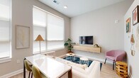 Located in the desirable Grandview Heights neighborhood of Columbus, Ohio, this single-floor unit at 826 Bowman Way offers a clean, contemporary design with an open and functional layout. Light wood-style flooring flows throughout the main living areas, complementing the neutral color palette and modern finishes found across the space.

The open-concept living and dining area is bright and welcoming, with large windows dressed in roller shades that allow generous natural light to fill the room. A wall-mounted media console anchors the living space, while the adjacent dining area provides a seamless transition to the kitchen.

The kitchen is well-appointed with gray flat-front cabinetry extending to the ceiling for ample storage, stainless steel appliances including a refrigerator, range, microwave, and dishwasher, light quartz countertops, and a classic subway tile backsplash. A window above the sink adds natural light to the workspace.

The bedroom features vaulted ceiling lines that lend an airy, open feel, with plush carpeting for added comfort. The bathroom is finished with large-format gray tile flooring, a white vanity with black hardware, and a glass-enclosed shower. A dedicated entryway nook with built-in bench seating, under-seat storage drawers, and a display shelf above adds a practical and organized welcome area to complete the space.
