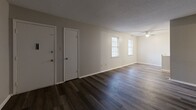 Located at 4001 Old Warren Rd in Pine Bluff, Arkansas, this single-story 2-bedroom, 2-bathroom residence offers a practical and well-organized floor plan. The combined kitchen and living room serves as the heart of the home, with the living area featuring dark hardwood-style flooring, textured ceilings, and ceiling fans that provide both function and airflow. Natural light enters through multiple windows fitted with blinds. The kitchen is equipped with white cabinetry, marble-patterned countertops, a black electric range with overhead ventilation, and a double stainless steel sink — offering ample workspace and storage. Both bedrooms are carpeted and include ceiling fans, closets, and windows that bring in natural light. The primary bedroom is a comfortable size, with access to an adjoining bathroom. The two bathrooms each feature a full tub-and-shower combination with clean white surrounds, wood-style vinyl flooring, and standard vanity fixtures. A hallway connects the private areas of the home, and a convenient entry closet is accessible from the main living space. The overall layout is efficient and straightforward, making this residence a solid and functional living option.