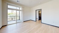 Located on Regent Street in Madison, WI, this modern single-floor unit offers three bedrooms and two full bathrooms with a thoughtfully designed open layout. The kitchen is a standout feature, showcasing dark espresso cabinetry, granite countertops, stainless steel appliances, and a large central island with pendant lighting — all set against light hardwood-style flooring that flows throughout the entire unit. A tall window bathes the kitchen in natural light and offers views of the surrounding neighborhood.

The living area is bright and open, with sliding glass doors that lead to a private balcony overlooking the vibrant Regent Street corridor, providing views of Madison's lively urban streetscape. The bedrooms are clean and minimalist, featuring dark-framed double doors and ample closet space. The primary bedroom is comfortably sized for a restful retreat.

Both bathrooms are finished with the same espresso-toned cabinetry and white countertops, with one featuring a tub-shower combination and the other a walk-in shower with chrome fixtures. Consistent use of light flooring, neutral walls, and dark door trim throughout creates a cohesive, contemporary aesthetic that is both functional and visually appealing.