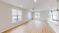 Located at 900 3rd St SE in Cedar Rapids, Iowa, this well-appointed 3-bedroom, 3-bathroom residence offers a thoughtfully designed single-floor layout. The open-concept kitchen and living area serves as the heart of the home, showcasing light hardwood flooring, recessed lighting, and a large central island with a quartz countertop, undermount sink, and stylish pendant lighting. White shaker cabinetry lines the kitchen walls, complemented by a full suite of stainless steel appliances including a refrigerator, range, and microwave. The living room is bright and airy, featuring multiple windows that frame views of the surrounding Cedar Rapids cityscape and allow generous natural light throughout the day, along with a ceiling fan for added comfort. The bedrooms are carpeted and comfortably sized, each equipped with ceiling fans and windows offering outdoor views. The primary bedroom connects to a well-sized bathroom featuring a clean white vanity with quartz countertop and an adjoining walk-in closet outfitted with extensive wire shelving for ample storage. Additional closet space throughout the unit provides practical organization. Clean white walls, consistent light hardwood floors in common areas, and modern finishes give the entire space a fresh, contemporary feel.