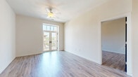 Located at Via Corso Ave in Mauldin, South Carolina, this well-appointed 2-bedroom, 2-bathroom residence offers a thoughtfully designed single-level layout with modern finishes throughout. The open-concept kitchen and living area serves as the heart of the home, showcasing light wood-toned cabinetry, a subway tile backsplash, dark granite countertops, stainless steel appliances including a refrigerator, range, and microwave, and a central island with pendant lighting above. Light hardwood-style flooring flows seamlessly through the main living areas, complementing the warm, neutral color palette. Bold dark-painted interior doors provide a striking contemporary contrast against the crisp white walls throughout. Both bedrooms are generously proportioned, each featuring ceiling fans, large windows that invite natural light, and private access to balconies through elegant French doors with transom windows, offering views of the surrounding architectural streetscape. The two bathrooms are finished with tile flooring and wood-toned vanities topped with granite counters. One bathroom features a walk-in shower, while the other offers a shower-tub combination. Two dedicated closets provide ample storage. The overall ambiance is clean, modern, and move-in ready.