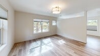 Located at 15948 Quarry Rd in Lake Oswego, Oregon, this thoughtfully designed one-bedroom, two-bathroom unit offers a clean, modern aesthetic across a single floor. Light wood-look flooring flows consistently throughout, creating a cohesive and inviting atmosphere.

The generously sized bedroom is a standout feature, accommodating a wide bank of windows fitted with cellular shades that allow for both natural light and privacy. Views of mature Pacific Northwest trees provide a serene, nature-filled backdrop. A wall-mounted mini-split system ensures year-round climate comfort, while a flush-mount ceiling light adds a contemporary finishing touch.

The living area mirrors this bright, open character, with multiple windows drawing in abundant natural light and stylish drum pendant lighting overhead. Crisp white walls and neutral tones throughout contribute to the unit's clean, airy feel.

The two bathrooms are finished with modern details, including wood-toned cabinetry, stone-look countertops, and tile-surround tub/shower combinations. Light wood-look tile flooring carries through both bathrooms, maintaining design continuity. One bathroom features a window for added ventilation and natural light, while the other offers a glass-enclosed shower with classic subway tile.

Overall, this Lake Oswego unit presents a well-appointed, contemporary living space with consistent modern finishes, ample natural light, and peaceful wooded views.