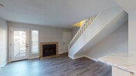 Located at 2533 Mariner Dr in Saint Louis, Missouri, this two-story home offers a well-organized layout across two distinct levels. The main floor is anchored by a bright living area with durable hardwood-style flooring, neutral gray walls, and a classic white-balustraded staircase that serves as a visual centerpiece. A tile-surround fireplace adds warmth and character to the living room, which also benefits from natural light through shuttered windows. The kitchen is thoughtfully appointed with white upper cabinetry, gray lower cabinetry, a marble-look countertop, and black appliances including a refrigerator, electric range, and over-the-range microwave. A dedicated in-unit laundry closet with a stacked Whirlpool washer and dryer is conveniently tucked just off the kitchen. The lower level also features additional open living or flex space with light flooring and closet access. Upstairs, the bedrooms are finished with plush carpeting and natural light from standard windows, offering a comfortable retreat. A ceiling fan provides added airflow to the upper level. The upper floor also includes a bathroom with a soaking tub and built-in shelving, along with closet storage to meet everyday organizational needs.