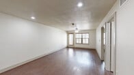 Located at 311 E Hickory St in Denton, TX, this 2-bedroom, 1-bathroom unit offers a well-organized, single-floor layout designed for comfortable everyday living. The living room serves as the heart of the home, featuring rich, dark hardwood-style flooring, recessed lighting, a ceiling fan, and a large window alongside a private entry door that fills the space with natural light. The galley-style kitchen is thoughtfully appointed with rich dark wood cabinetry, granite-look countertops, a double stainless steel sink, and a full suite of stainless steel appliances including a refrigerator, range, and microwave. Both bedrooms are carpeted and equipped with ceiling fans, providing a comfortable, quiet retreat. The primary bedroom offers a cozy, functional footprint, while the second bedroom includes a window for natural light. A dedicated closet adds practical storage. The shared full bathroom is well-finished, featuring tile-surround tub and shower, dark wood vanity cabinetry, granite countertops, and hardwood-style flooring. Textured ceilings are present throughout the unit, contributing to its character. The exterior of the building features a brick facade with greenery along the front, adding to its curb appeal in this established Denton neighborhood.