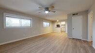 Located at 200 Primrose Cir in New Braunfels, TX, this single-story, 2-bedroom, 1-bathroom home offers a clean, updated interior with a practical and efficient layout. Light-toned luxury vinyl plank flooring runs throughout the entire home, creating a cohesive and easy-to-maintain aesthetic.

The open living and dining area is bright and welcoming, featuring dual windows that bring in natural light and ceiling fans for added comfort. The space flows directly into the kitchen, which is visible through a pass-through opening. The galley-style kitchen is well-appointed with crisp white shaker cabinets, marble-look countertops, a black electric range with overhead ventilation, a refrigerator, and a secondary exterior door for convenient access.

Both bedrooms are comfortable and well-sized, each equipped with ceiling fans and windows. The generously sized primary bedroom offers ample natural light. The home includes three closets in total, providing notable storage throughout. A dedicated utility room adds further functional space.

The full bathroom features a subway-tiled tub and shower surround, a toilet, and a window for ventilation and natural light. A hallway connects the main living areas to the bedrooms and bathroom, maintaining a smooth and logical flow throughout the home.