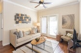 This single-floor residence offers a thoughtfully designed layout with warm, cohesive finishes throughout. The living room serves as the heart of the home, featuring rich hardwood flooring, crown molding, a ceiling fan, and a set of French doors that invite natural light and provide outdoor access. The space is well-proportioned, offering room for comfortable seating and entertaining.

The kitchen is well-equipped and functional, showcasing rich dark cabinetry, granite countertops, a tasteful subway tile backsplash, and a full suite of stainless steel appliances including a refrigerator, range, microwave, and dishwasher. A track lighting fixture illuminates the space effectively, and the hardwood flooring continues seamlessly from the adjoining living areas.

Two bedrooms provide restful retreats, each featuring plush carpeting, ceiling fans, and windows with blinds that allow for natural light control. One bedroom includes access to a walk-in closet with built-in shelving, while the other benefits from a vaulted ceiling that adds an airy sense of volume.

The bathroom is clean and well-appointed, featuring tile flooring, dark wood cabinetry, and a tub-shower combination with white subway tile surround. Crown molding is carried throughout the unit, lending a consistent and polished architectural detail to every room.