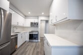 Located at 873 Warwick Dr in Burlington, Ontario, this two-storey home offers a thoughtfully designed layout across two floors, with two bedrooms and two bathrooms. The main floor features an open-concept arrangement connecting the living room and kitchen. The kitchen is a standout space, equipped with stainless steel appliances including a French door refrigerator, dishwasher, stove, and built-in microwave, all complemented by sleek white cabinetry with modern hardware and generous counter space. Light hardwood-style flooring runs throughout both levels, creating a cohesive and clean aesthetic. The living room is bright and airy, benefiting from natural light through a front-facing window fitted with a roller blind. A convenient two-piece bathroom is also located on the main floor. Upstairs, the spacious primary bedroom features its own window with outdoor views and ample natural light, while the second bedroom includes a built-in sliding-door closet. The upper-level full bathroom is finished with crisp white tile, a soaker tub with shower, and clean chrome fixtures. Soft grey walls, white trim, and recessed lighting are consistent throughout, lending the home a fresh, modern ambiance.