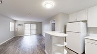 Located in Long Beach, California, this single-story 2-bedroom, 3-bathroom residence offers a well-organized and functional layout with a clean, contemporary aesthetic throughout. Wood-style flooring runs continuously across the living areas, bedrooms, and kitchen, lending a cohesive and modern feel to the entire space.

The kitchen is appointed with crisp white cabinetry, white appliances including a gas range, microwave, refrigerator, and a built-in peninsula with open shelving below — ideal for additional storage or casual seating. The kitchen opens directly into the living area, creating a connected, open-concept feel.

The living room is bright and airy, featuring a sliding glass door with vertical blinds that draws in natural light and provides outdoor access. A wall-mounted HVAC unit ensures year-round comfort.

The two bedrooms are generously proportioned, with the primary bedroom offering ample square footage. Both rooms feature neutral gray walls, wood-style flooring, and windows fitted with horizontal blinds for natural light control and privacy.

The three bathrooms are finished with white vanities, built-in cabinetry for storage, and tub/shower combinations with clean white tile surrounds. The overall palette of soft grays, whites, and warm wood tones creates a calm, move-in-ready environment throughout this well-appointed Long Beach residence.