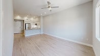 Located at 16101 Murphy Ave in Irvine, CA, this single-floor unit presents a clean, modern aesthetic with thoughtfully designed living spaces. The open-concept living and kitchen area is anchored by light wood-look flooring and a ceiling fan, creating a bright and airy atmosphere. Recessed lighting and pendant fixtures illuminate the space, adding warmth to the neutral gray tones found throughout.

The kitchen is a standout feature, outfitted with white shaker-style cabinetry, a subway tile backsplash, and a full suite of stainless steel appliances including a gas range, built-in microwave, refrigerator, and dishwasher. A peninsula with a quartz-style countertop provides additional workspace and seating potential, while a deep single-basin sink with a professional-style faucet adds a polished touch.

The bedrooms are finished with plush carpeting and soft neutral walls, offering a comfortable retreat. One bedroom features a sliding window with views to an adjacent outdoor area, while another includes a built-in closet with rod storage. Both rooms benefit from generous ceiling height and efficient HVAC venting.

The bathroom is finished with light-toned tile flooring, white cabinetry, a wood-accented countertop, an illuminated mirror, and a full tub-shower combination with open shelving — combining practicality with a modern, spa-inspired feel.