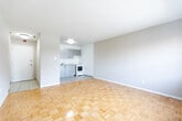 Located at 3330 Weston Road in Toronto's northwest end, this 1-bedroom, 1-bathroom unit offers a compact yet functional layout across a single floor. The space is characterized by warm parquet hardwood flooring that extends throughout the main living areas and bedroom, lending a classic, timeless aesthetic to the interior.

The entrance welcomes residents with light-toned tile flooring and a flush ceiling light fixture, providing a clean transition into the living space. The combined kitchen and living room area is thoughtfully arranged, with the kitchen featuring updated grey cabinetry, granite-style countertops, a subway tile backsplash, and a full-size refrigerator — offering a modern and practical cooking environment. Light tile flooring completes the kitchen area.

The bedroom is a comfortable size, equipped with a closet, a window that draws in natural light and provides outdoor views, and the same warm parquet flooring found throughout the unit. Neutral, warm-toned walls create a calm and versatile atmosphere.

The bathroom is finished with crisp white horizontal wall tiles surrounding a full soaker tub and shower combination, complemented by chrome fixtures and a wall-mounted mirror, delivering a clean and bright bathing space. The overall design of this unit prioritizes functionality and simplicity, making it a practical and inviting living space.