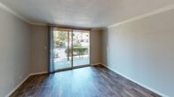 Located on the second floor at 1812 Trinity Ave in Walnut Creek, CA, this apartment offers a thoughtfully designed single-level layout with a blend of carpet and wood-style flooring throughout. The living area is bright and comfortable, featuring sliding glass doors that open onto a private balcony overlooking lush, mature trees and greenery — a serene outdoor retreat. A wall-mounted HVAC unit provides convenient climate control. Crown molding and a ceiling fan with light fixture add character to the living and dining areas. The galley-style kitchen is well-equipped with warm wood cabinetry, dark granite-style countertops, stainless steel appliances including a refrigerator, electric range, and built-in microwave, along with a stainless sink. The kitchen opens directly toward the balcony, enhancing the sense of connectivity to the outdoors. A dedicated dining nook features wood-style flooring, crown molding, chair rail detailing, and a flush-mount ceiling light. The bedrooms are carpeted and filled with natural light, with one room featuring a large multi-pane corner window. The bathroom includes warm wood vanity cabinetry, dark granite-style countertops, a wide vanity mirror with a multi-bulb light fixture, and a full soaking tub with tile surround. Textured ceilings are consistent throughout the unit.