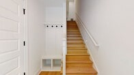 This two-story residence offers a generous 1530 square feet of living space, thoughtfully divided between two floors. The ground level encompasses 780 square feet, while the upper floor provides 750 square feet. The home boasts two bedrooms, including a spacious primary bedroom of 210 square feet, and three full bathrooms for added convenience.

The interior is characterized by an open and airy feel, enhanced by large windows that flood the rooms with natural light. Hardwood floors throughout add warmth and elegance to the space. The layout includes a combined kitchen and living room area, perfect for modern living and entertaining. Three closets provide ample storage solutions.

The staircase, visible in the image, features white railings that complement the crisp white walls, creating a bright and clean aesthetic. Recessed lighting adds to the contemporary ambiance. The overall design emphasizes a sense of spaciousness and flow between areas, making this home both functional and visually appealing.
