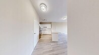 Located at 1920 Weston Rd in Toronto's Weston neighbourhood, this 2-bedroom, 1-bathroom unit offers a clean, modern interior with a consistent and cohesive design throughout. Light wood-look flooring runs across the entire unit, complementing the warm neutral tones of the walls and creating a bright, airy atmosphere.

The combined kitchen and living area forms the heart of the unit. The kitchen is well-appointed with white shaker-style cabinetry, a light stone countertop, white subway tile backsplash, stainless steel appliances including a refrigerator and range, and a peninsula that provides additional workspace and separates the kitchen from the living area. Track lighting adds a functional finishing touch overhead.

The living room benefits from large windows that invite natural light and offer views of the surrounding neighbourhood, with baseboard heating units running along the exterior walls. Both bedrooms continue the light, neutral aesthetic, with the primary bedroom offering a generous footprint and a double-door closet for ample storage. Each bedroom is served by natural light through well-sized windows.

The bathroom features a full soaker tub with marble-style tiled surround, a toilet, and light wood flooring, maintaining the clean, contemporary feel found throughout the unit. A hallway connects all rooms efficiently, completing this well-laid-out home.