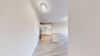 Located at 1920 Weston Rd in Toronto's Weston neighbourhood, this 2-bedroom, 1-bathroom unit offers a clean, modern interior with a consistent and cohesive design throughout. Light wood-look flooring runs across the entire unit, complementing the warm neutral tones of the walls and creating a bright, airy atmosphere.

The combined kitchen and living area forms the heart of the unit. The kitchen is well-appointed with white shaker-style cabinetry, a light stone countertop, white subway tile backsplash, stainless steel appliances including a refrigerator and range, and a peninsula that provides additional workspace and separates the kitchen from the living area. Track lighting adds a functional finishing touch overhead.

The living room benefits from large windows that invite natural light and offer views of the surrounding neighbourhood, with baseboard heating units running along the exterior walls. Both bedrooms continue the light, neutral aesthetic, with the primary bedroom offering a generous footprint and a double-door closet for ample storage. Each bedroom is served by natural light through well-sized windows.

The bathroom features a full soaker tub with marble-style tiled surround, a toilet, and light wood flooring, maintaining the clean, contemporary feel found throughout the unit. A hallway connects all rooms efficiently, completing this well-laid-out home.