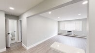 Located at 560 Beachway Ave in Keansburg, NJ, this single-floor unit has been thoughtfully renovated with clean, modern finishes throughout. Light gray walls and light-toned luxury vinyl plank flooring create a cohesive, contemporary aesthetic across all areas of the space.

The open living area is bright and airy, illuminated by recessed lighting embedded in smooth white ceilings. A structural beam detail adds subtle architectural character, while a window unit and baseboard heating ensure year-round climate control. A wide window allows natural light to filter in, enhancing the sense of openness.

The kitchen is well-appointed with crisp white shaker cabinetry, a subway tile backsplash, and a full suite of stainless steel appliances, including a gas range, microwave, and refrigerator. A white peninsula with a stone-look countertop provides additional prep space and casual seating, connecting the kitchen to the main living area.

The bathroom features floor-to-ceiling white subway tile surrounding a soaking tub with an overhead rain showerhead and matte black fixtures, offering a clean, spa-like finish. The overall layout is efficient and well-organized, making excellent use of the available space while maintaining a bright, move-in-ready presentation throughout.